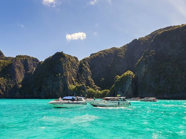 Turquoise lagoon surrounded by jungle cliffs