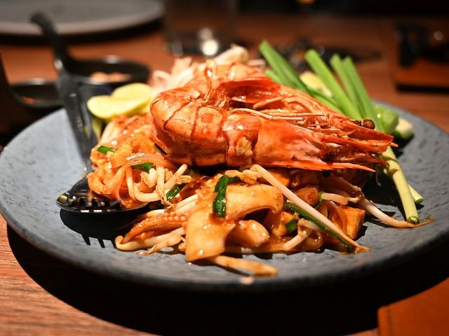 Thai prawn noodle dish served on a dark stone plate